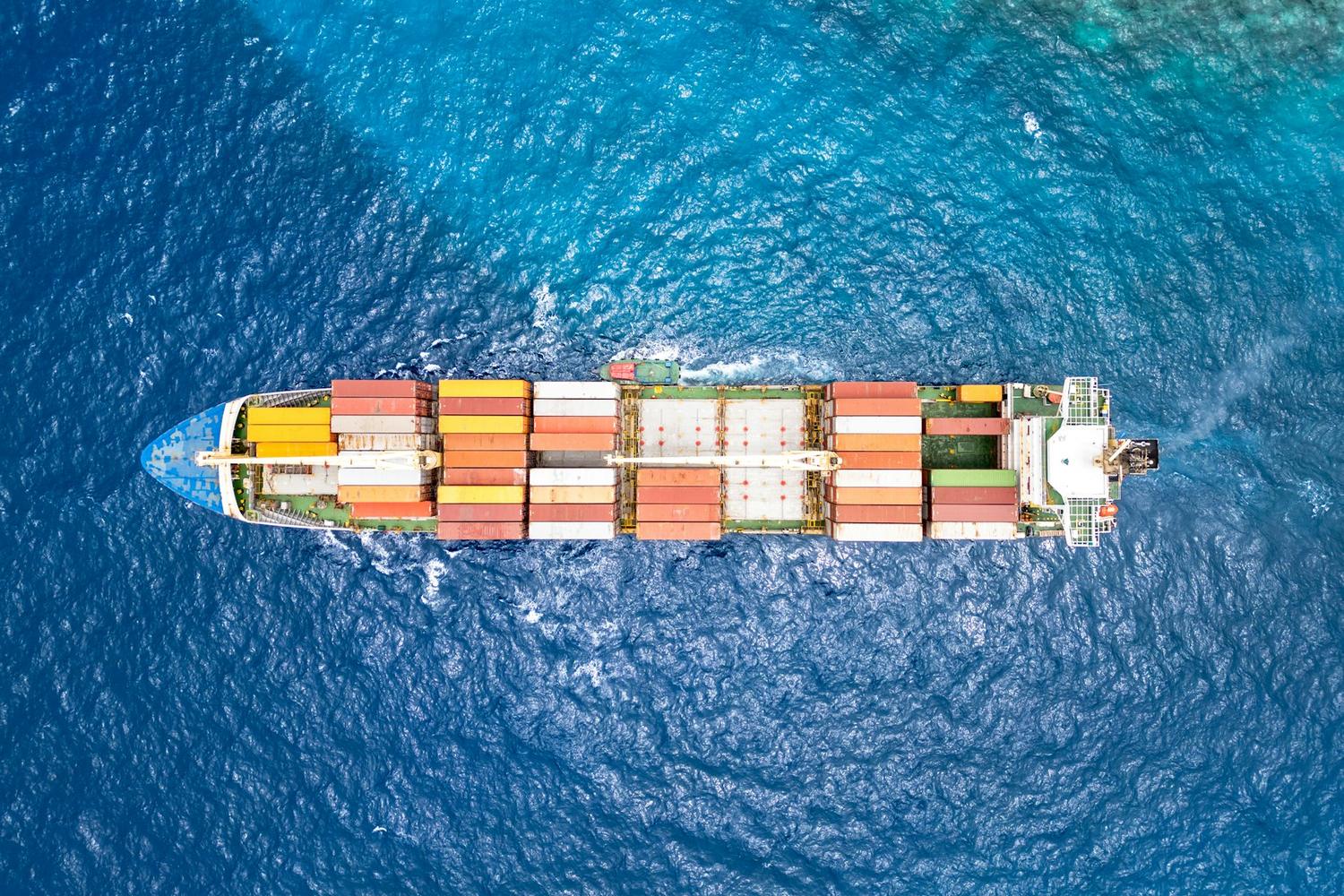Buque portacontenedores navegando en mar abierto, visto desde arriba.